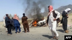 This photograph taken on May 21, 2016 shows Pakistani local residents gathering around a destroyed vehicle hit by a drone strike in which Taliban leader Mullah Akthar Mansur is believed to have been killed.