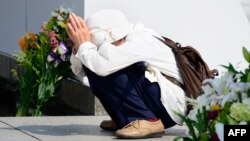 An elderly woman prays for victims of the 1945 atomic bombing of Hiroshima in front of the cenotaph at the Peace Memorial Park in Hiroshima on August 5.