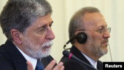 Iran's Foreign Minister Manuchehr Mottaki (right) listens to his Brazilian counterpart Celso Amorim as he addresses a joint news conference in Tehran.