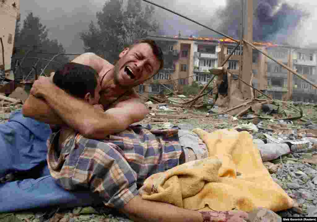 A Georgian man cries as he holds the body of a loved one after a Russian bombardment on August 9 in Gori, Georgia, near the border of the breakaway region of South Ossetia.