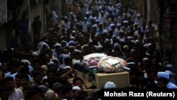 Pakistani mourners carry the coffins of blast victims during their funeral a day after a suicide bomb attack in Lahore last month.