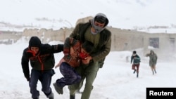 FILE: Survivors of an avalanche run to get relief goods distributed by an Afghan army helicopter in the Paryan district of Panjshir province.