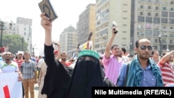 A woman holds the Koran aloft as supporters of ousted Egyptian President Muhammad Morsi take to the streets in Cairo on August 16. 