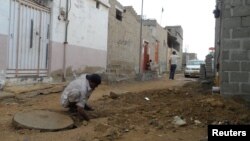 A laborer works to connect a house to a new sewage line in Karachi's Orangi Town slum.