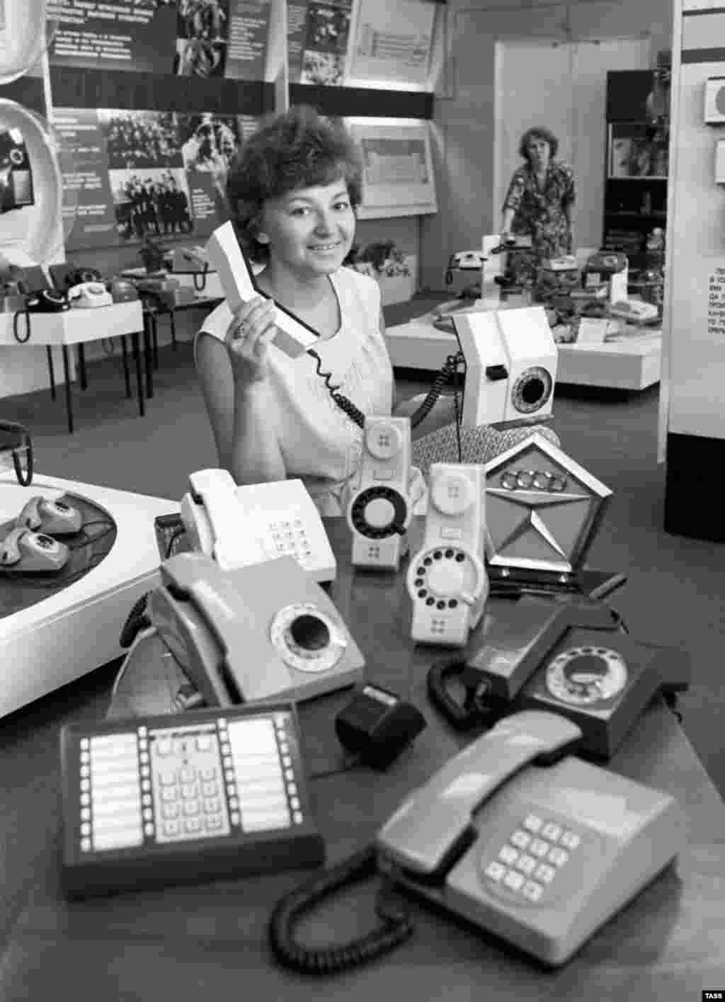 A woman displays products and a State Quality Mark of the U.S.S.R., the highest certification of quality,&nbsp;in the shop at the Perm telephone production plant in 1982.