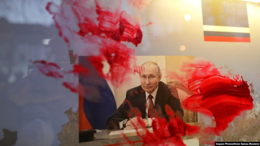 Розмазаний червоною фарбою портрет очільника Росії Володимира Путіна під час антивоєнної акції біля російського посольства в Румунії. Бухарест, 26 лютого 2022 року