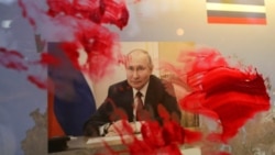 Розмазаний червоною фарбою портрет очільника Росії Володимира Путіна під час антивоєнної акції біля російського посольства в Румунії. Бухарест, 26 лютого 2022 року