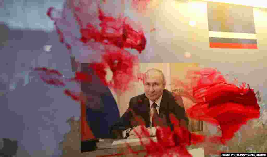 Розмазаний червоною фарбою портрет президента Росії Володимира Путіна під час антивоєнної акції біля російського посольства в Румунії. Бухарест, 26 лютого 2022 року