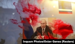 Розмазаний червоною фарбою портрет очільника Росії Володимира Путіна під час антивоєнної акції біля російського посольства в Румунії. Бухарест, 26 лютого 2022 року