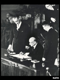 Robert Schuman (ministrul francez al Afacerilor Externe) semnează Tratatul NATO pentru Franța, Washington, D.C., 4 aprilie 1949