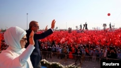 Прэзыдэнт Турэччыны Рэджэп Таіп Эрдаган з жонкай вітаюць людзей на мітынгу, арганізаваным на знак пратэсту супраць спробы вайсковага перавароту. Стамбул, 7 жніўня 2016 году