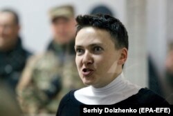 Ukrainian lawmaker Nadia Savchenko reacts inside a defendants' cage during a court hearing in Kyiv on March 23.