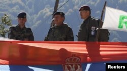 Kosovo Force (KFOR) Major General Erhard Drews of Germany stands along the barricades in front of a Serbian flag at the closed Serbia-Kosovo border crossing of Brnjak, on October 19. 