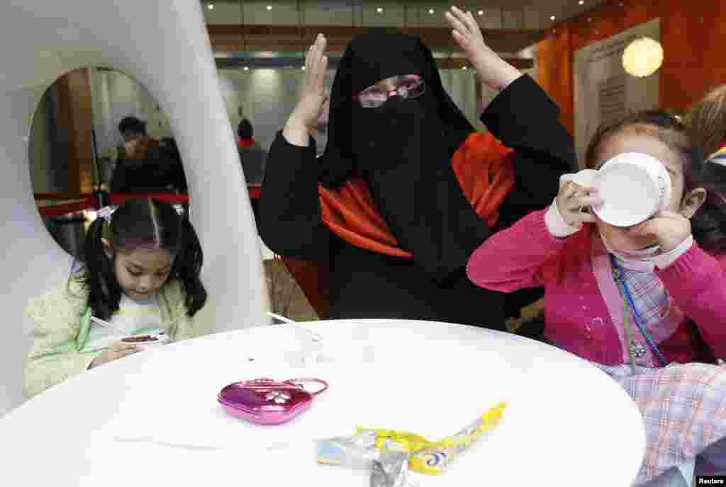 Brenda talks while her daughters eat ice cream. "I know I'm in a non-Muslim country and so I try to respect the rules," Brenda says. "Sometimes people say nice things about my children or they smile at me and I try to smile back at them. I know they can't see my face but I hope they know I'm smiling with my eyes."