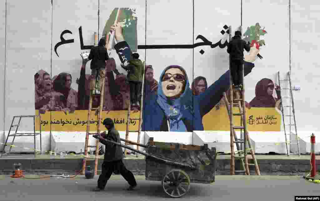 Afghan artists graffiti a wall at the Women&#39;s Affairs Ministry in Kabul to mark International Women&#39;s Day. (AP/Rahmat Gul)