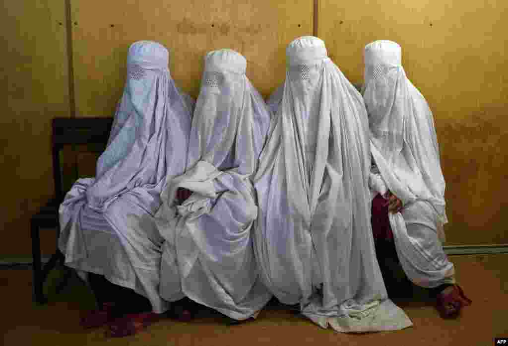 Жанчыны зь ліку аўганскіх уцекачоў чакаюць на сканаваньне вачэй ў адным з імігранцкіх цэнтраў ў Пэшавары, Пакістан.