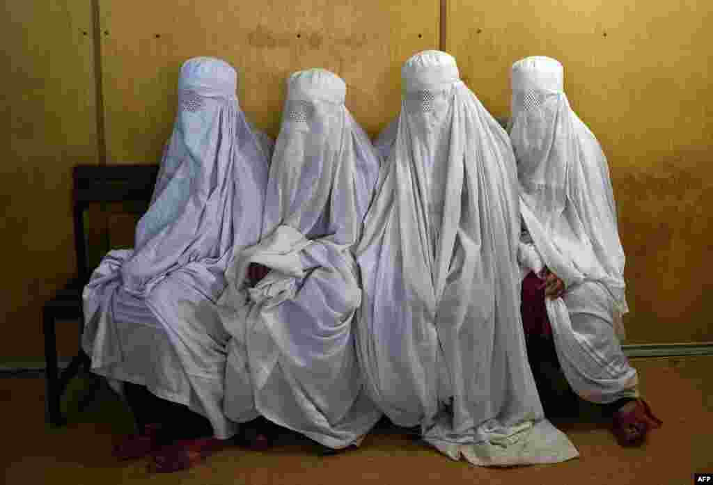 Female Afghan refugees wait to have their eyes scanned at the UNHCR registration center in Peshawar, Pakistan. (AFP/Abdul Majeed)