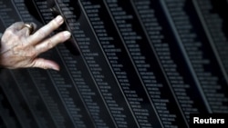O femeie atinge numele victimelor de Ziua Holocaustului