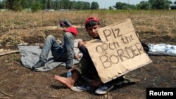 Migrant koji štrajkuje glađu sa transparentom na kome piše "Otvorite granice, molim vas", Horgoš 25. jul 2016.