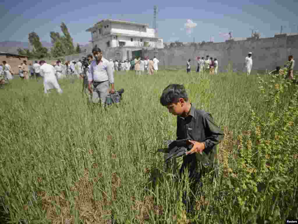 Pakistan - Dok su novinari i fotoreporteri okružili kuću u kojoj je ubijen Bin Laden, ovaj dječak je odlučio da sakupi ostatke od pucnjave predhodne noći, Abbottabad, 03.05.2011. Foto: Reuters / Akhtar Soomro 