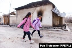 Дети идут мимо сгоревшего дома в селе Масанчи, Жамбылская область. 26 февраля 2020 года.