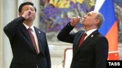 Кытайдын президенти Си Цзинпин жана Орусия президенти Владимир Путин газ келишимине кол коюлганджан кийин тост көтөрүшүүдө. Шанхай, 21-май 2014