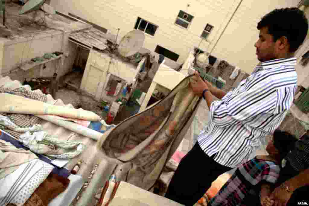 A man folds a blanket after a night on the roof.