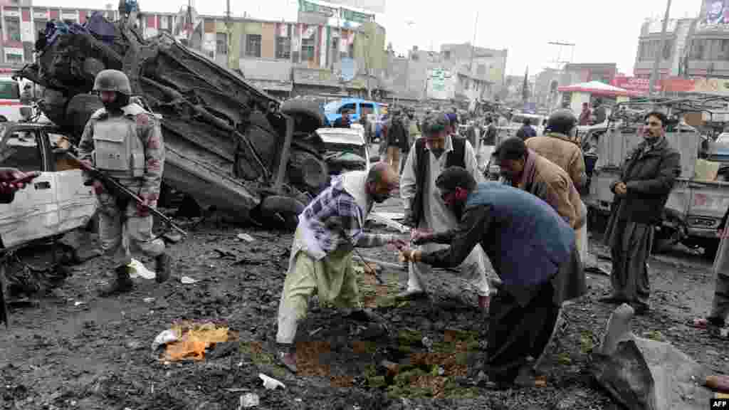 Pakistani security personnel examine the site of one of the explosions.