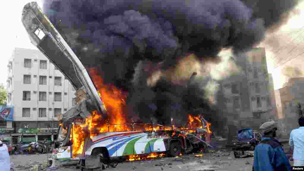 A bus is seen in flames at the site of a bomb explosion that killed six people in the Pakistani city of Karachi (Reuters)