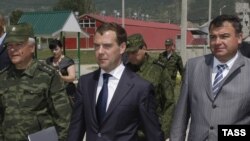 Russian Defense Minister Anatoly Serdyukov (right) with President Dmitry Medvedev (center) during their visit to South Ossetia in July -- Russian officials also said Moscow will "do everything to ensure the security of the Russian state, the security of t