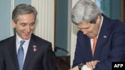 U.S. Secretary of State John Kerry (right) checks his watch as Moldovan Prime Minister Iurie Leanca looks on, before they deliver remarks to the media on March 3 at the State Department in Washington, D.C.