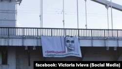 Белсенділердің Мәскеу өзені үстіндегі Крымский көпіріне ілген Олег Сенцовты босатуды талап еткен баннері. Мәскеу, 8 тамыз 2018 жыл.