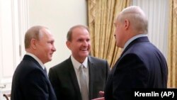 Președintele rus Vladimir Putin, stânga, discută cu magnatul ucrainean Viktor Medvedciuk, în centru, și cu președintele belarus Aleksandr Lukașenka, în timpul unei întâlniri la Sankt Petersburg, 18 iulie 2019.