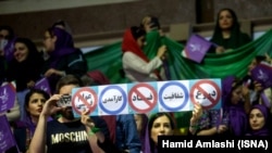 A president Rouhani supporter holds an anti corruption banner during Rouhani's campaign rally in Tehran on Tuesday May 9, 2017.