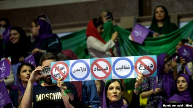 A president Rouhani supporter holds an anti corruption banner during Rouhani's campaign rally in Tehran on Tuesday May 9, 2017.