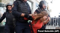 Police detain a woman during an unsanctioned rally in the center of Moscow on July 27.