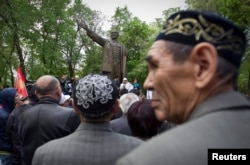 Участники митинга в Алматы рядом с памятником советскому вождю Владимиру Ленину.