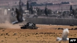 Birds fly near a Turkish tank during clashes between Turkish Army and Islamic State militants at Elbeyli in the southern region of Kilis, near the Syrian border, on September 4.