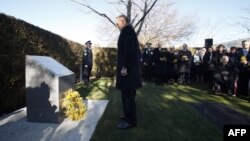 Australian Prime Minister Tony Abbott (center) lays a wreath for the Australian victims of Malaysia Airlines flight MH17 at a ceremony unveiling a memorial on the first anniversary of the plane's downing, outside Parliament House in Canberra on July 17