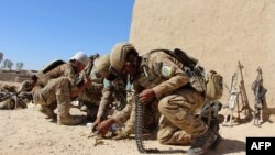 Afghan National Army commandos load their rifles during a battle with Taliban militants in Helmand province, where the group has a strong presence.