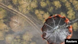 A helicopter carries water before releasing it over a forest fire in central Russia on August 10.