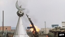 Российский солдат прицеливается на мусульманский полумесяц на развалинах мечети (архивное фото)