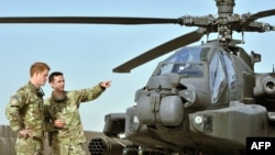 Britain's Prince Harry (left) is shown an Apache helicopter upon his arrival at Camp Bastion, in Afghanistan, on September 7.