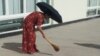 turkmenistan. woman with brooms are cleaning streets ahead of Elder's Council in Turkmenabat