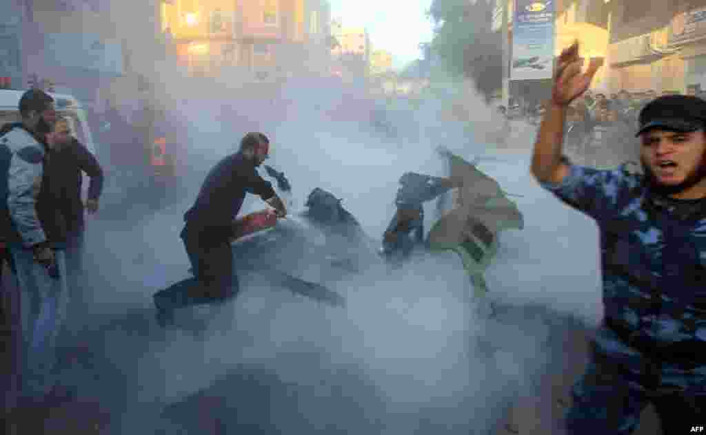 Palestinians extinguish flames on the car of Ahmed al-Jaabari, head of the military wing of the Hamas movement, after it was hit by an Israeli air strike in Gaza City on November 14. 