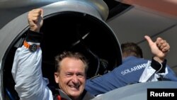 Andre Borschberg, in the cockpit of "Solar Impulse," celebrates after completing his historic flight.