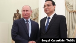 Russian President Vladimir Putin (left) meets with Chinese Premier Li Keqiang in Moscow on September 18.