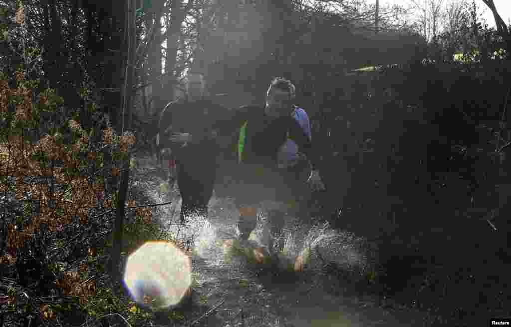 British Prime Minister David Cameron competes in the Great Brook Run, a mile-long course through water and mud, at Chadlington in southern England. (Reuters/Eddie Keogh)