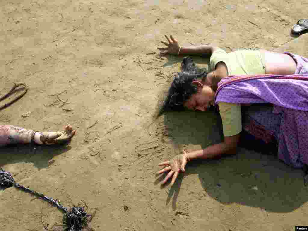 An Indian woman mourns the death of her relative (R) who was killed in tsunami on Sunday in Cuddalore, some 180 km (112 miles) south of the southern Indian city of Madras December 28, 2004. REUTERS/Arko Datta 