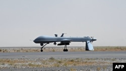 A U.S. Predator unmanned drone armed with a missile sits on the tarmac of Kandahar military airport. 